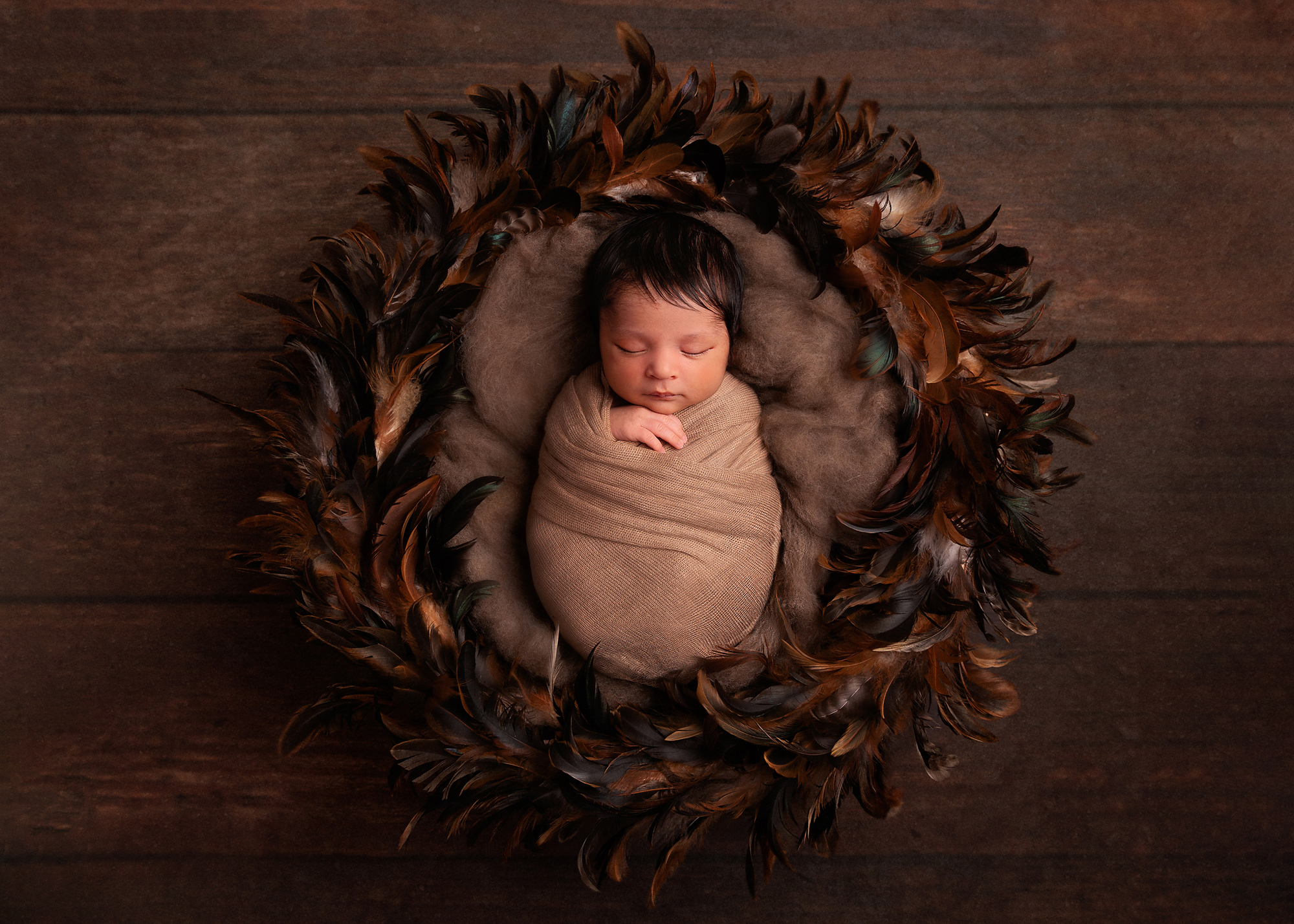 newborn-baby-wrapped-sleeping-in-brown-wreath-by-newborn-photographer-surrey
