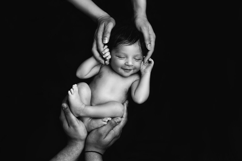 black-and-white-newborn-baby-smiling-by-Surrey-Newborn-Baby-Photographer