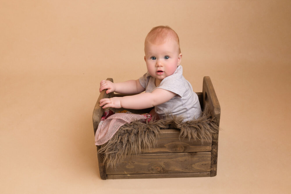 little girl in rustic crate by surrey baby photographer