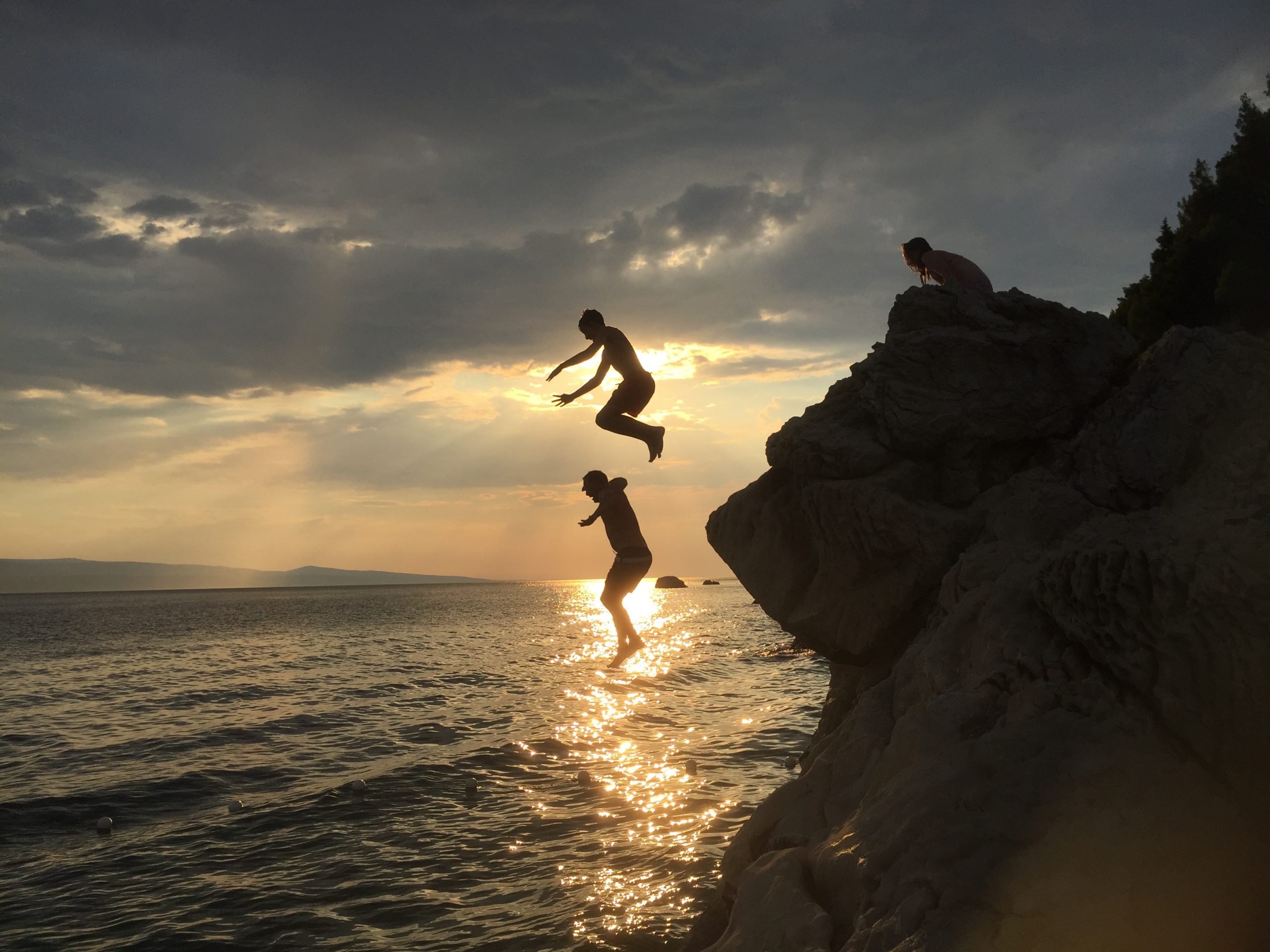 Family-jumping-off-cliff-into-sea-family-fun