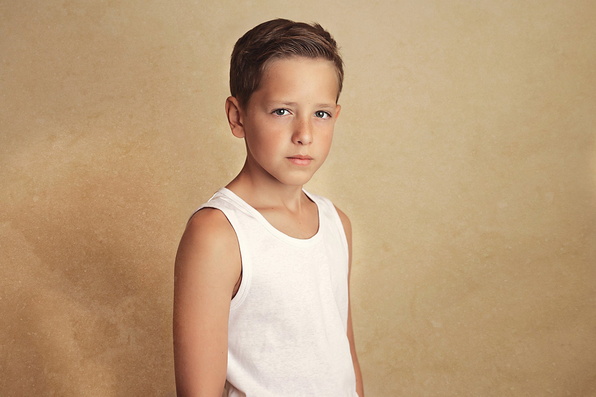 young-boy-in-white-vest-posing-child-portrait-photographer