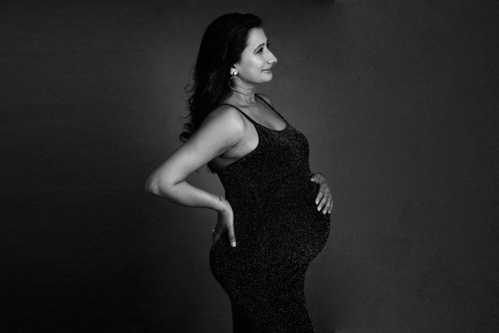 black and white pregnant woman in maternity dress by Surrey Maternity Photographer