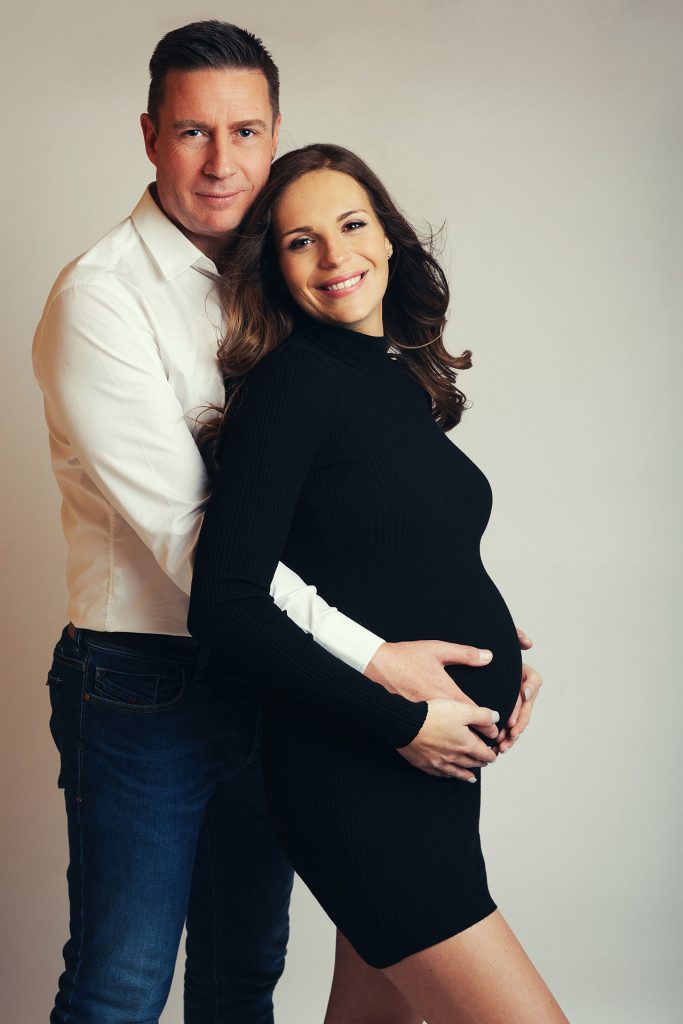 pregnant woman being cuddled by partner by Surrey Newborn Photographer