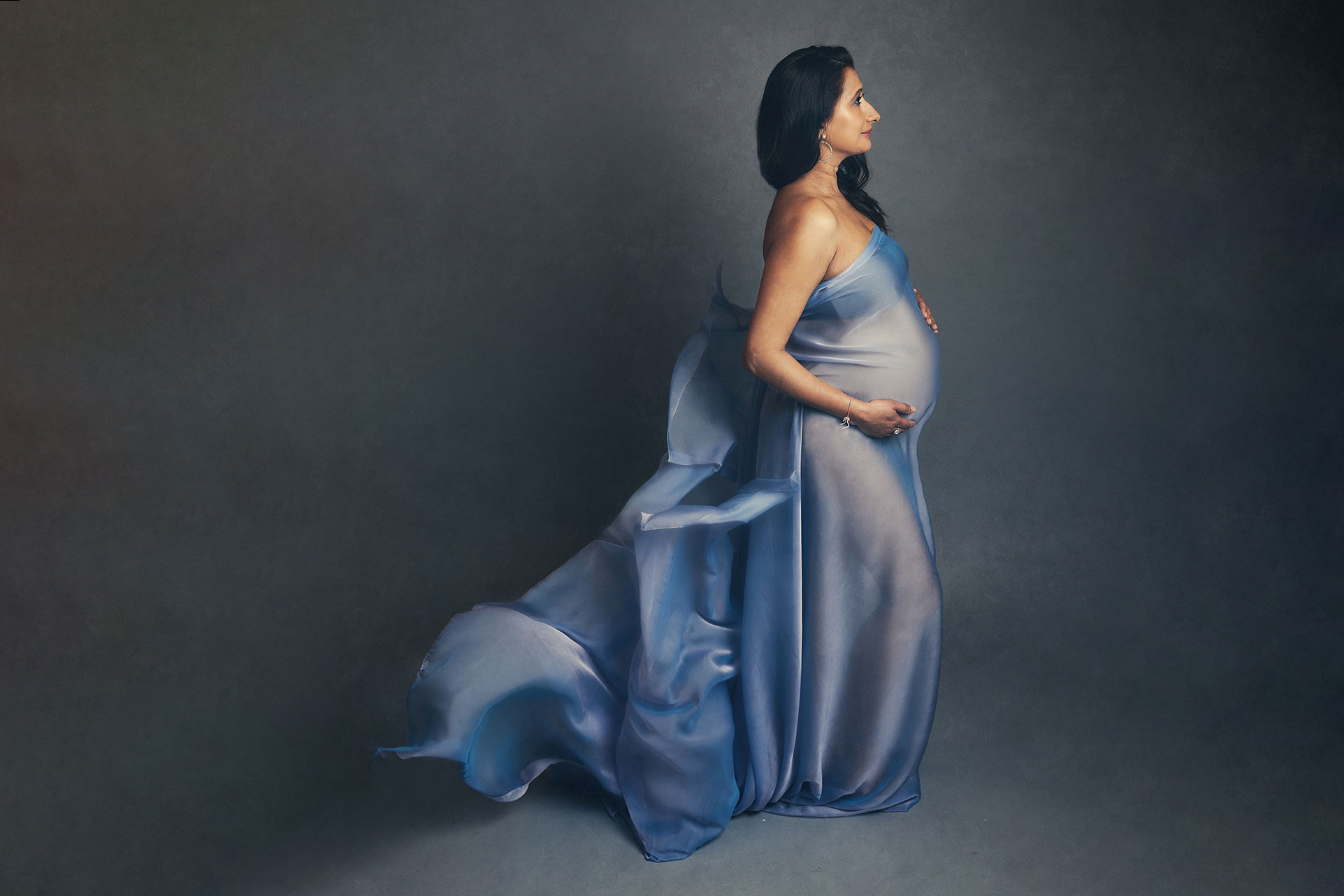 pregnant lady with flowing blue wrap by Surrey Newborn Photographer