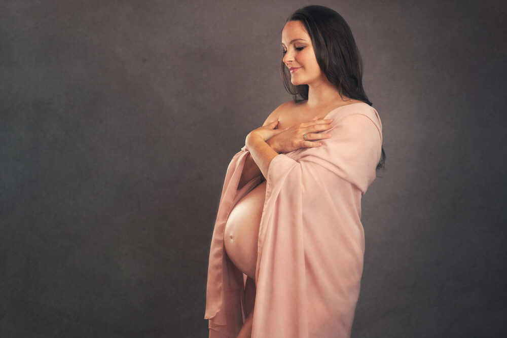 pregnant-woman-in-pink-silk-wrap-Surrey-Maternity-Photographer